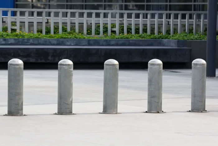 Five concrete bollards built into the sidewalk